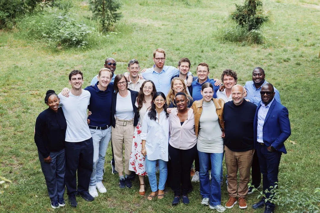 Large group of EIDU team members posing together on a lawn