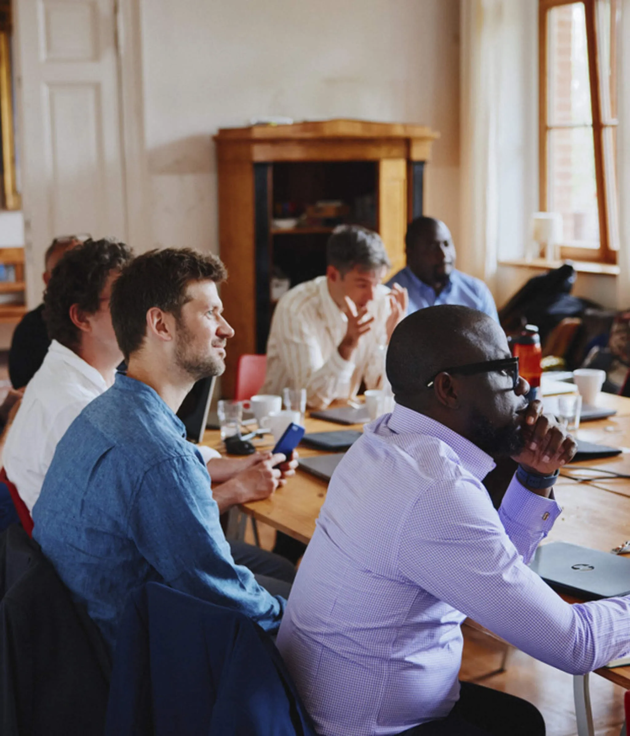 EIDU team members listening around a meeting table during an offsite