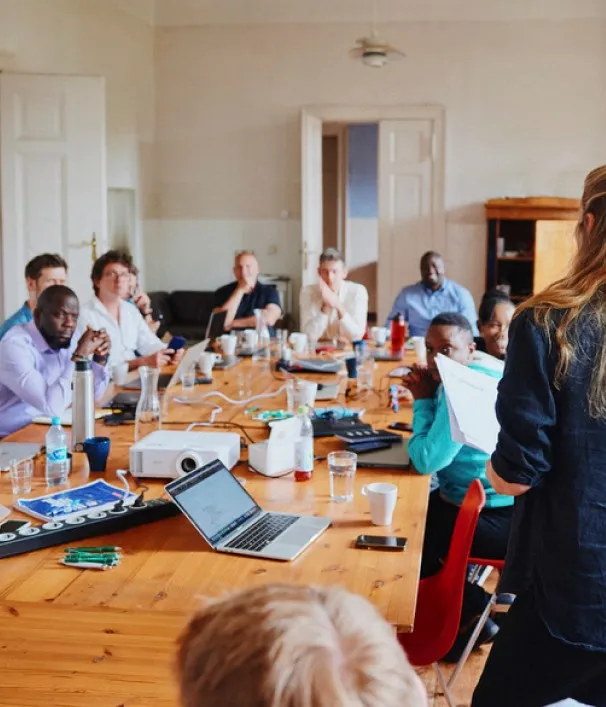 Colleague presenting to EIDU team members gathered around a long meeting table